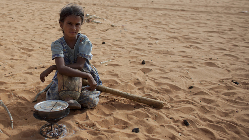 A young girl cooks rice in a refugee camp in Mauritania (picture: Reuters)