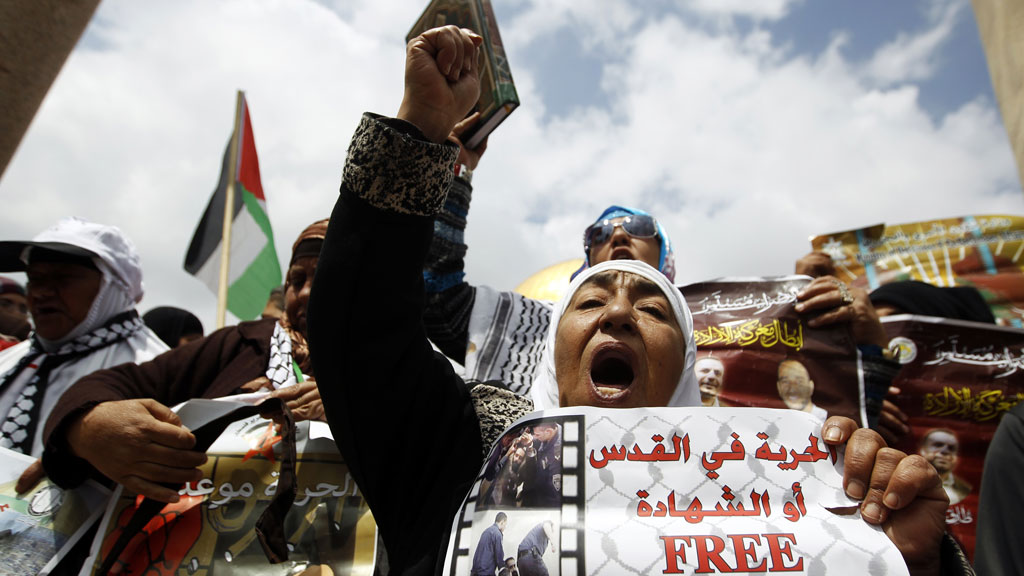 Palestinians hold placards calling for the release of prisoners held by Israel (pic: Reuters)