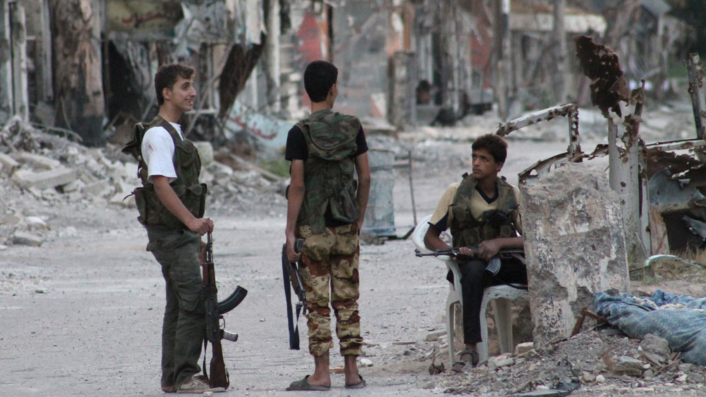 Rebel fighters secure an heavily damaged street in Syria's eastern town of Deir Ezzor (G)
