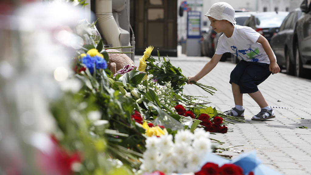 A little boy lays flowers outside of the Dutch Embassy in Moscow, Russia (credit: Reuters)