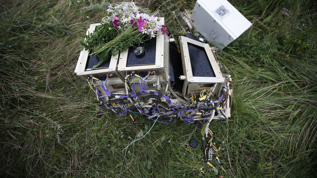 Flowers rest upon debris at the scene of the crash (credit: Reuters)