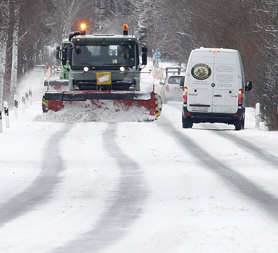 Cars make their way slowly as snowploughs clear a road. London's Gatwick airport has shut its runway while British Airways cancels all flights from Heathrow, on a day of snow chaos. Reuters