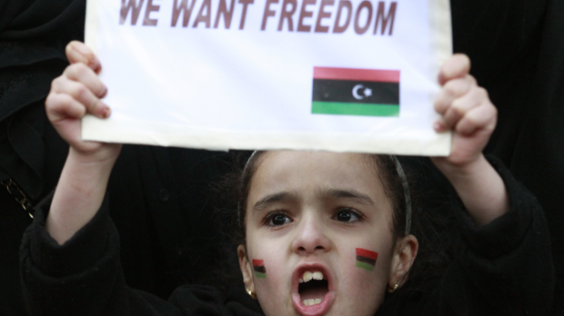 Libya: young girl holds up anti-Gaddafi placard. (Reuters)