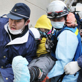 Japan: 16-year-old Jin Abe is carried by rescue workers from the rubble in Ishinomaki City (Reuters)