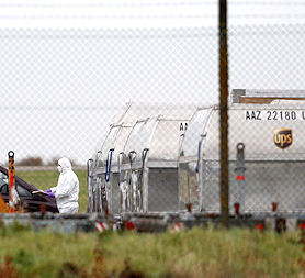 A forensic officer at East Midlands Airport investigates the suspicious package