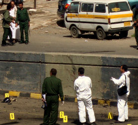 Yemeni police forensic officers inspect the scene of a suicide bombing that targeted the convoy of the British ambassador in Sanaa. (Getty)