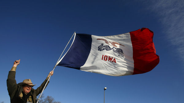 Man waves Iowa state flag. (Reuters)